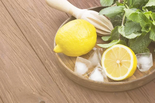 Ingredientes para la limonada - limón, menta, hielo en bandeja de madera en un — Foto de Stock