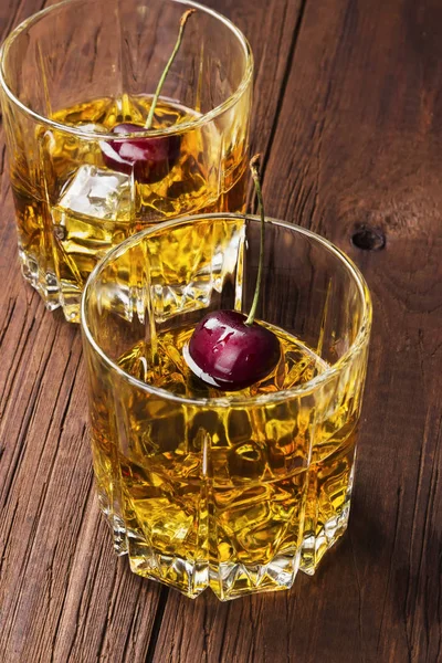 Kokteyl kiraz ahşap arka iki gözlük ile viski üzerinden