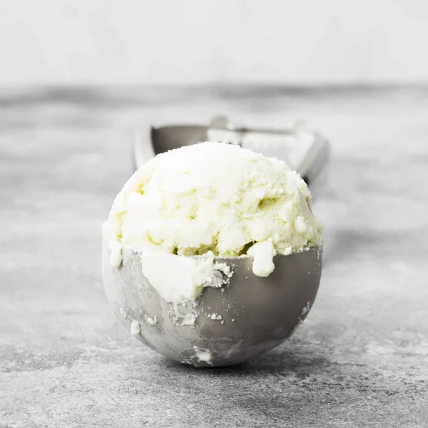 Mint ice cream in spoon on a gray background