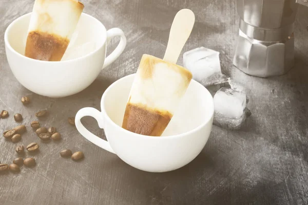 Koffie ijs ijslollys in witte koppen op een donkere achtergrond. T — Stockfoto