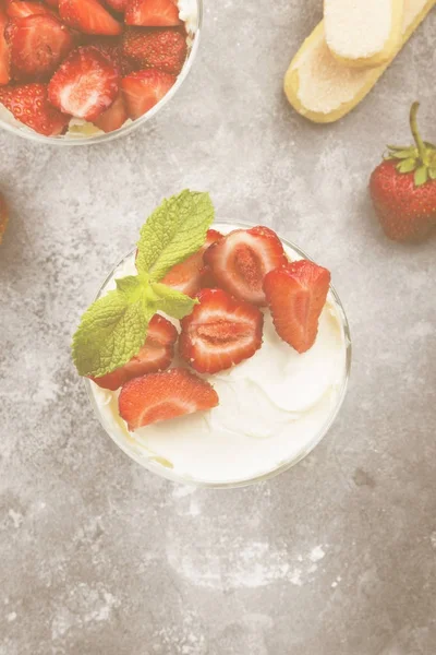 Dessert-Tiramisu mit Erdbeere auf grauem Hintergrund. Ansicht von oben. — Stockfoto