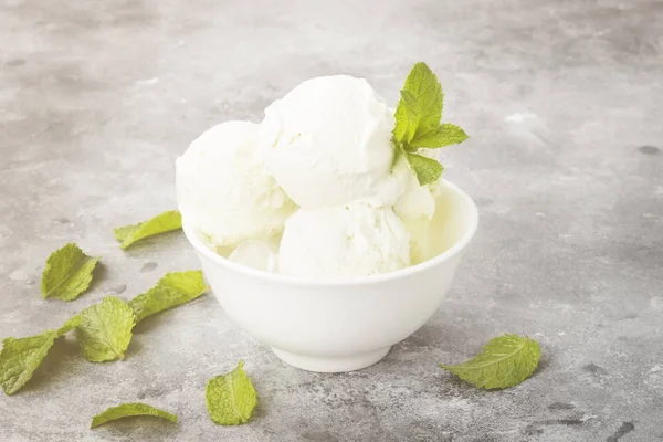 Mint ice cream in bowl on a gray background. Toning