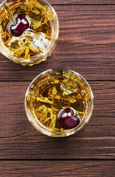 Kokteyl kiraz ahşap arka iki gözlük ile viski üzerinden