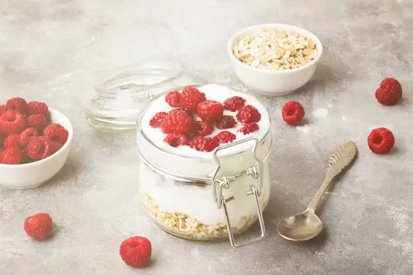 stock image Glanola in glass jar with raspberry and mint on a gray backgroun