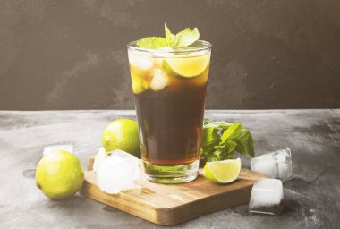 Bir bardak koyu arka plan üzerinde kokteyl Cuba Libre. Kopya alanı.