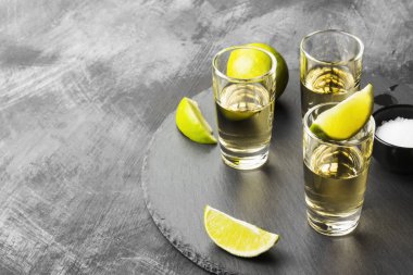 Tekila limon ve tuz karanlık bir arka plan üzerinde. Uzay kopyalayın. Foo