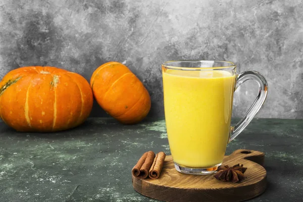 Latte de calabaza con especias (canela, anís) sobre un fondo verde —  Fotos de Stock