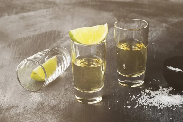 Tequila s limetkou a sůl na tmavém pozadí. Tónovaný — Stock fotografie