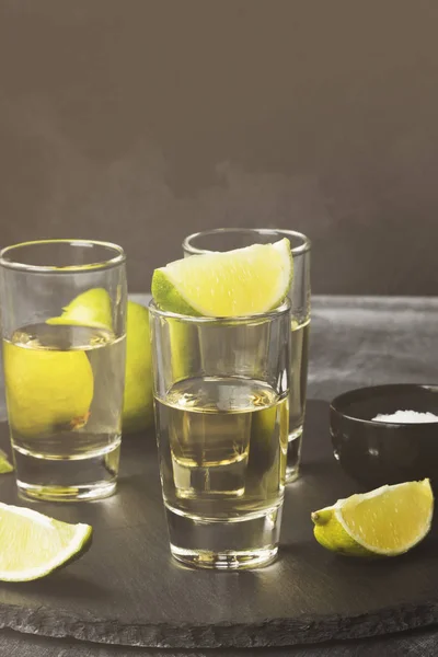 Tequila met limoen en zout op een donkere achtergrond. Toned — Stockfoto