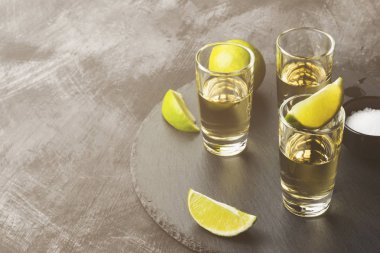 Tekila limon ve tuz karanlık bir arka plan üzerinde. Uzay kopyalayın. Foo