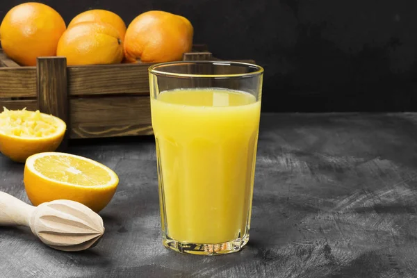 Oranges and fresh orange juice on a black background