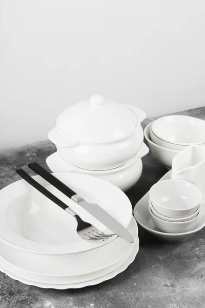 Limpar utensílios de mesa brancos em um fundo cinza — Fotografia de Stock