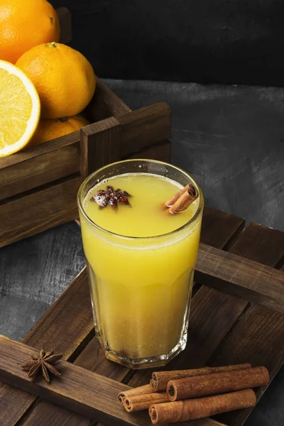 Зимний горячий напиток из апельсинов и специй на черном фоне — стоковое фото