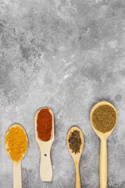 Gri bir arka plan üzerinde çeşitli baharatlar. Görünümü en çok, uzay kopyalayın. Gıda 