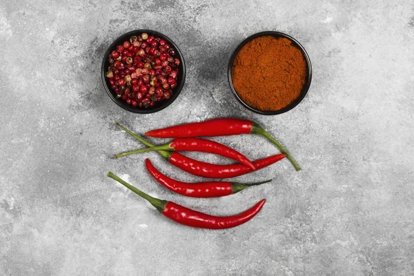 Gri bir arka plan üzerinde kırmızı acı biber. Üstten Görünüm. Gıda arka plan