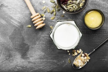 Granola yoğurt, bal, fındık, meyve karanlık bir arka plan ile. Hedef