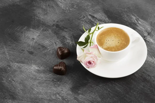 Café expresso em uma xícara branca, rosa e chocolates em um — Fotografia de Stock