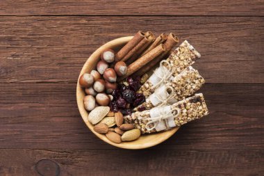 Mısır gevreği barlar ile fındık, çilek ve tarçın bir ahşap backgrou üzerinde
