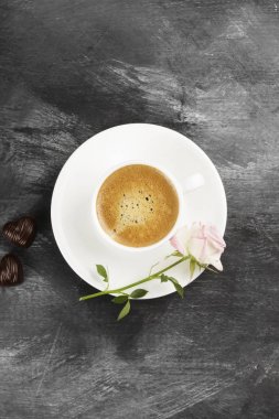 Espresso kahve beyaz bir fincan, pembe Gül ve çikolata üzerinde bir 