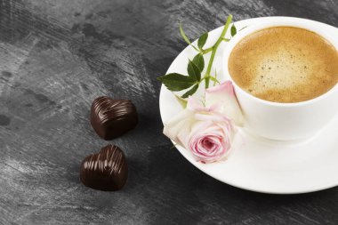 Espresso kahve beyaz bir fincan, pembe Gül ve çikolata üzerinde bir 