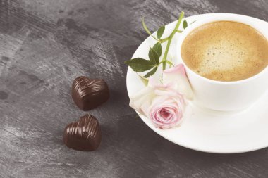 Espresso kahve beyaz bir fincan, pembe Gül ve çikolata üzerinde bir 