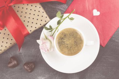 Espresso kahve beyaz bir fincan, pembe bir gül, bir hediye ile bir kırmızı t