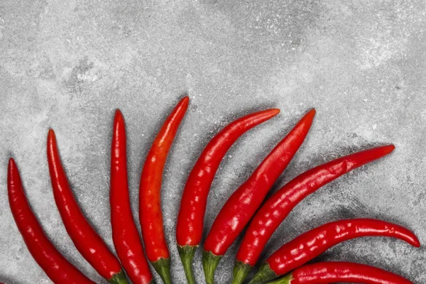 Pimenta quente vermelha em um fundo cinza. Vista superior, espaço de cópia. Alimentos — Fotografia de Stock