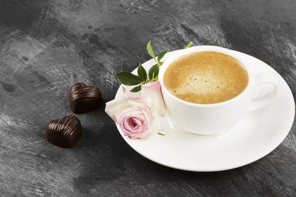Café expresso em uma xícara branca, rosa e chocolates em um — Fotografia de Stock