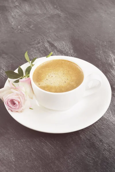 Кофе эспрессо в белой чашке и розовая роза на темном бэкгро — стоковое фото