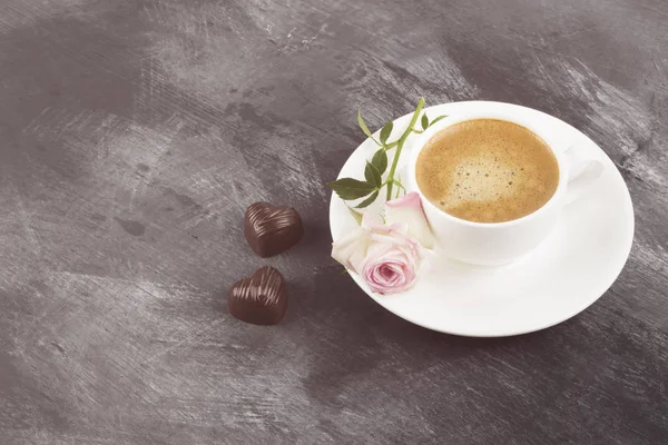 Café expresso em uma xícara branca, rosa e chocolates em um — Fotografia de Stock