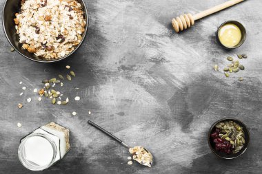 Granola yoğurt, bal, fındık, meyve karanlık bir arka plan ile. Hedef