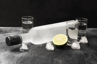 Siyah arka planda shot bardaklarında soğuk votka.
