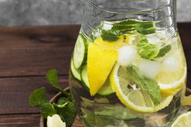 Salatalık, limon ve nane bir ahşap üzerine cam sürahi içinde içkiyle Detoks