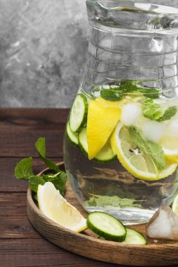 Salatalık, limon ve nane bir ahşap üzerine cam sürahi içinde içkiyle Detoks