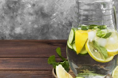 Salatalık, limon ve nane bir ahşap üzerine cam sürahi içinde içkiyle Detoks