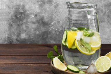 Salatalık, limon ve nane bir ahşap üzerine cam sürahi içinde içkiyle Detoks