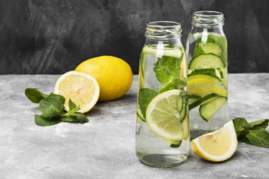 Detoks içecek salatalık, limon ve nane gri bir arka plan üzerinde