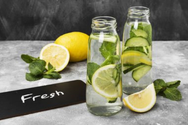 Detoks içecek salatalık, limon ve nane gri bir arka plan üzerinde