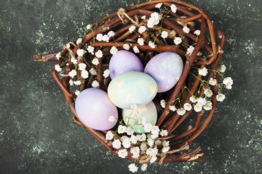 Paskalya için çok renkli yumurta yuvada yeşil arka çiçekli