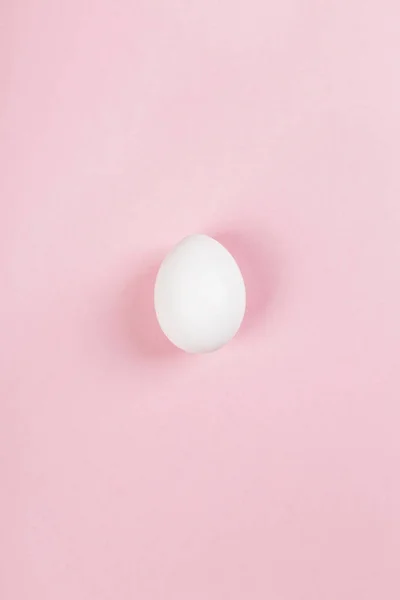 White egg on pink background. Top view — Stock Photo, Image