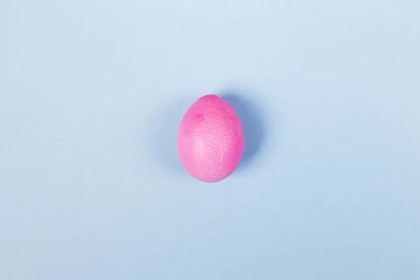 Pink egg on blue background. Top view — Stock Photo, Image