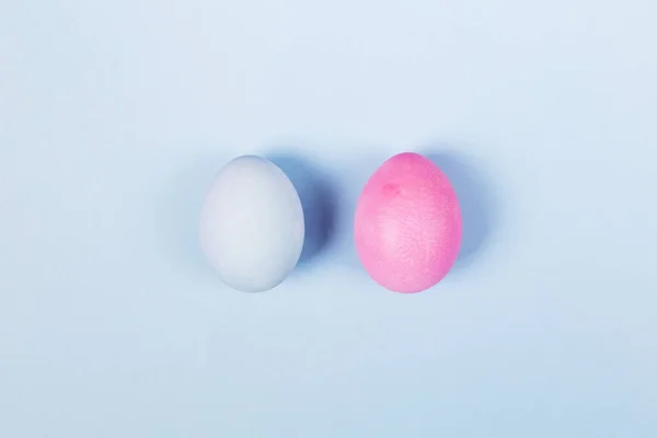 Blue and pink eggs on blue background. Top view — Stock Photo, Image