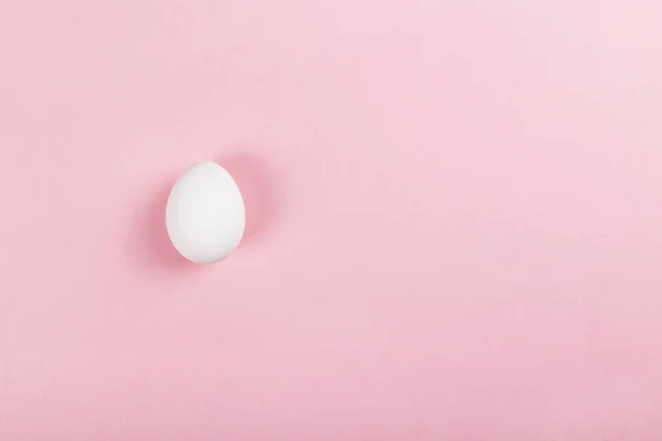 White egg on pink background. Top view, copy space — Stock Photo, Image