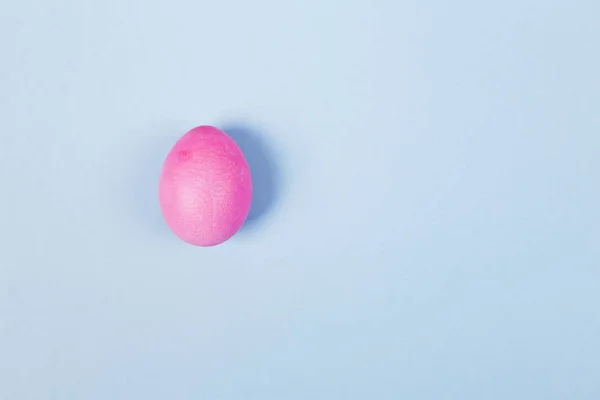 Pink egg on blue background. Top view, copy space — Stock Photo, Image