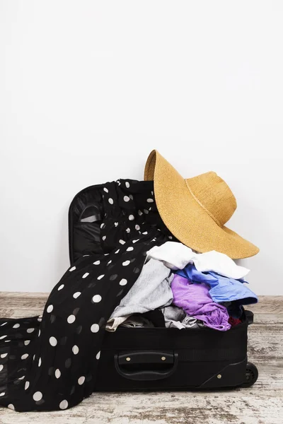 Embalagem descuidada de roupas em mala preta — Fotografia de Stock
