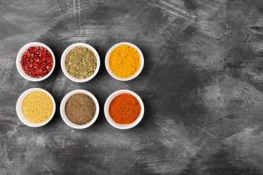 Siyah arka plan üzerine kase içinde çeşitli baharatlar. Üstten Görünüm, kopya girintili