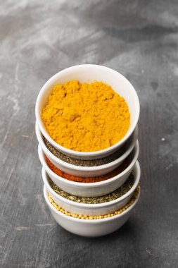 Siyah arka plan üzerine kase içinde çeşitli baharatlar