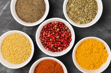 Siyah arka plan üzerine kase içinde çeşitli baharatlar. Üstten Görünüm. Gıda arka