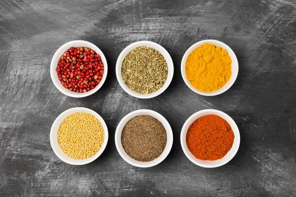 Various spices in bowls on black background. Top view. Food back — Stock Photo, Image