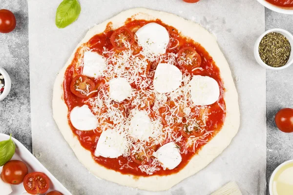 Pasta per pizza e ingredienti per pizza su sfondo grigio. Superiore vi — Foto Stock